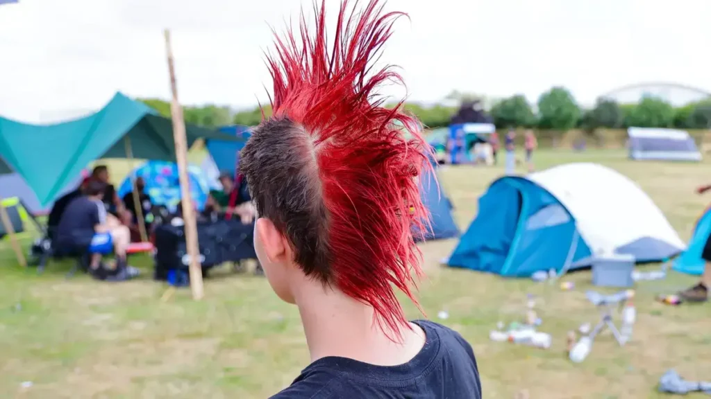 Punk auf Sylt, mit Campingausrüstung und roten Haaren.