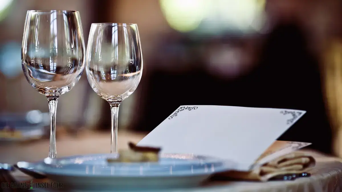 Weingläser neben einer Speisekarte im Restaurant.